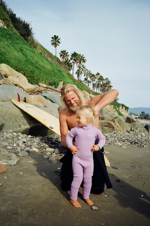 Child in Dusty Lavender Mano kids 3mm GBS seams full wetsuit walking to the ocean | Abysse