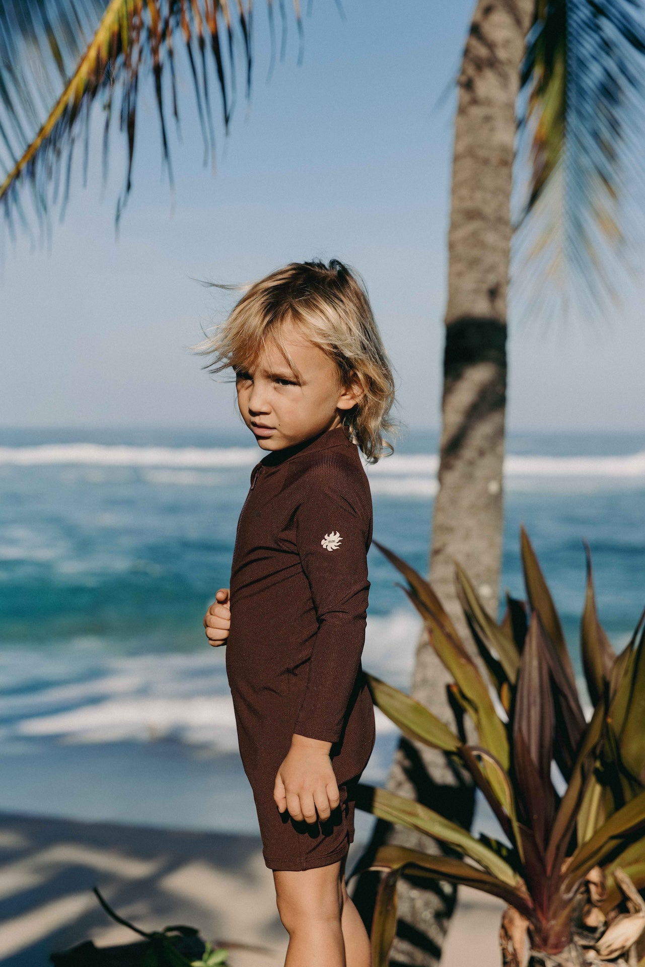 Introducing the Mini Dekker Surf suit, a long sleeve one-piece rash guard, with boy cut shortie bottom