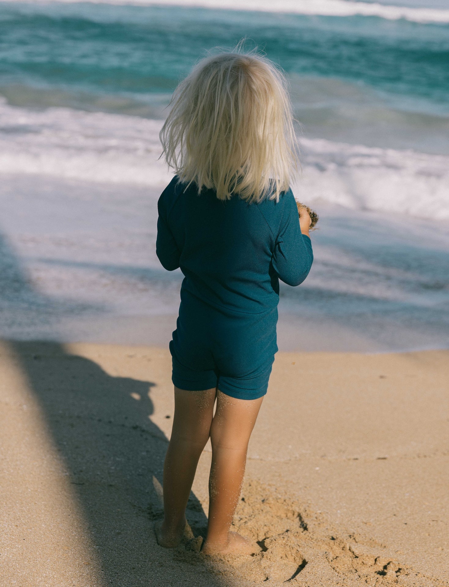 Introducing the Mini Dekker Surf suit, a long sleeve one-piece rash guard, with boy cut shortie bottom.