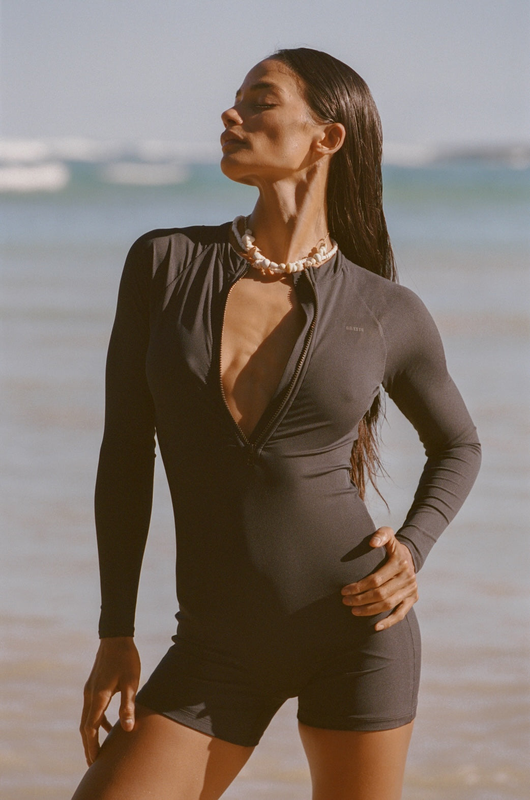 Woman wearing a black long-sleeve swimsuit on a beach